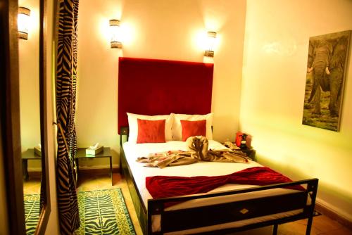 a bedroom with a bed with a red headboard at Riad Du Petit Prince in Marrakech