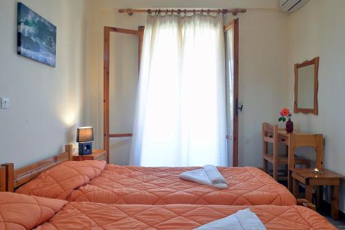 アカラヴィにあるFeeloxenia Corfu Apartmentsのベッドルーム1室(ベッド2台、窓付)
