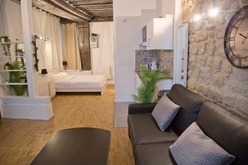 - un salon avec un canapé et une horloge murale dans l'établissement New Modern Saint Germain Paris Center, à Paris