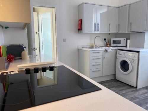 a kitchen with a washing machine and a washer and dryer at The Santiago Suite - sleeps 10 in Southport