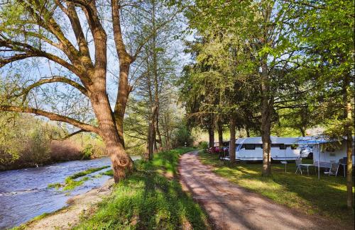 a road next to a river with a camper and trees at Chalet Beau Rivage in Gunsbach