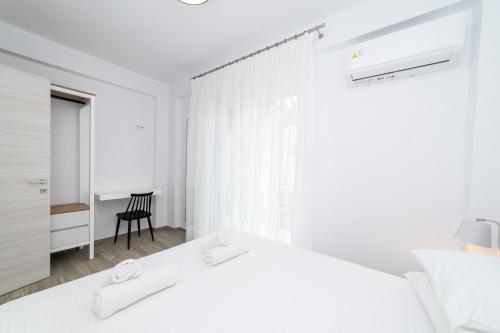 a white bedroom with a white bed and a chair at Anastasia Residential Complex in Ofrínion