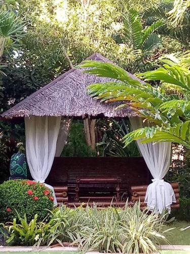 a pavilion with a bench in a garden at Palmhill Villa in Boracay