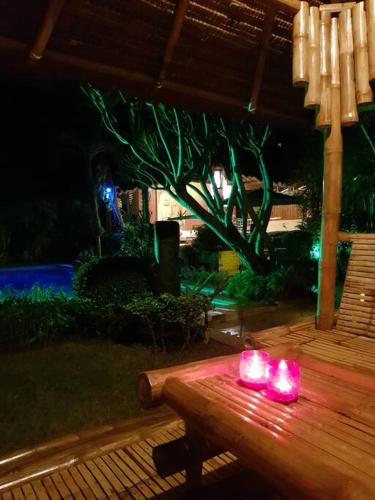 a group of pink candles sitting on a wooden bench at Palmhill Villa in Boracay