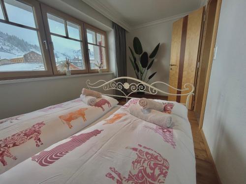 una camera con letto e lenzuola bianche e rosa di Haus Wallis by stayFritz - Ski-In Ski-Out Apartments am Arlberg a Warth am Arlberg