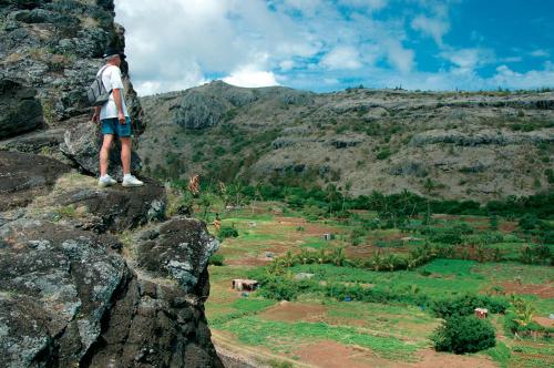 a man standing on top of a rocky mountain at Chez Ronald Guest House in Rodrigues Island