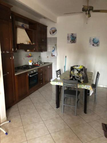 uma cozinha com uma mesa e um fogão forno superior em Il villino em Santa Marinella