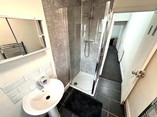 uma casa de banho com um lavatório e um chuveiro em Three Rose Manor At Warwick Road Near Birmingham Airport em Birmingham