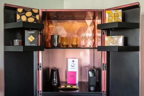 a drink cabinet with wine glasses and other items at Fauchon l'Hôtel Paris in Paris