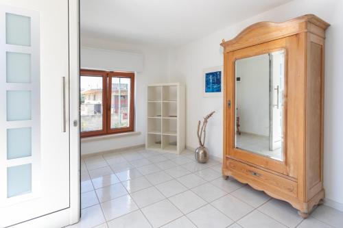 een kamer met een spiegel en een houten kast bij Quadrilocale Raffaello a Ugento - Apulia Home in Ugento