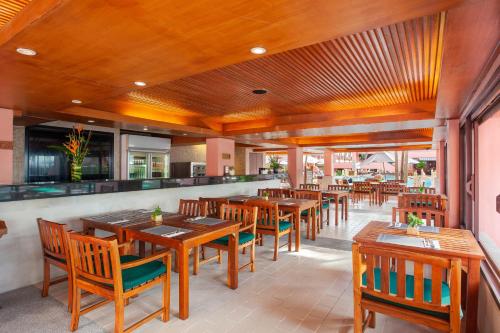 an empty restaurant with wooden tables and chairs at 普吉岛-瓶庐海景度假酒店 Phuket PL Seaview Resort in Patong Beach