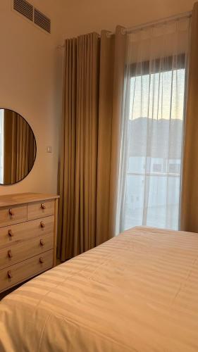 a bedroom with a bed and a dresser and a window at The Ocean Villa in Fujairah