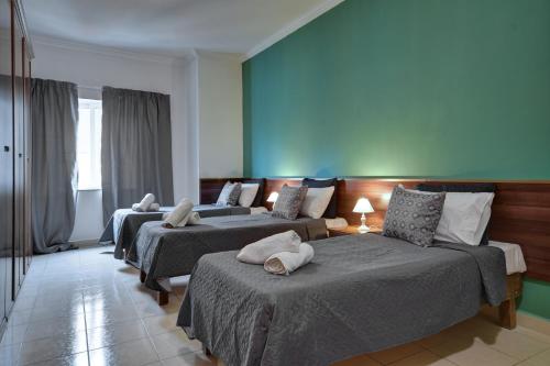 a room with three beds with pillows on them at Unique Seaview Apartments and Penthouse in Central St Julians in St Julian's
