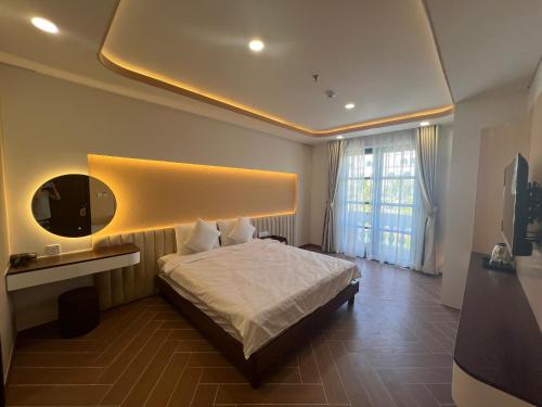 sypialnia z białym łóżkiem i lustrem w obiekcie Tanya Phu Quoc Hotel w Duong Dong