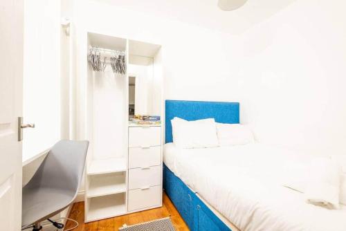 um quarto com uma cama com uma cabeceira azul e uma secretária em Central 2 Bedroom Apartment - South Street - St Andrews em St. Andrews