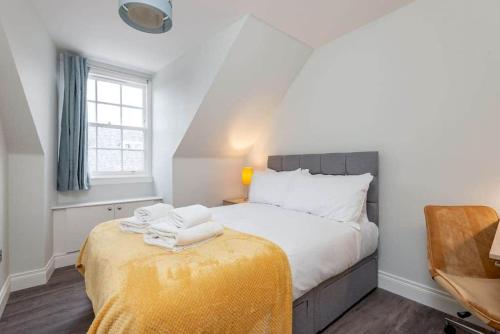 a bedroom with a bed with towels on a table at Luxury Penthouse Apartment on South Street in St. Andrews