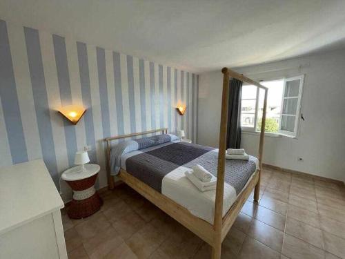 a bedroom with a bed and a striped wall at Mitjana - Apartamento con piscina in Ciutadella