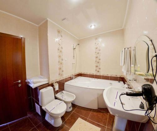 y baño con bañera, aseo y lavamanos. en Kristina Hotel, en Zaporozhye