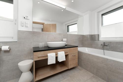 a bathroom with a sink and a toilet and a tub at A Casa Elements in Serfaus