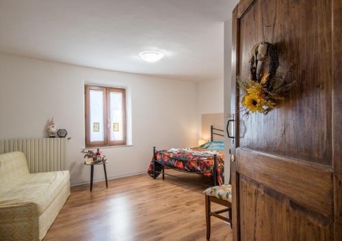 ブオンコンヴェントにあるCasa Al Colle Buonconventoの木製のドア、ベッドが備わる客室です。