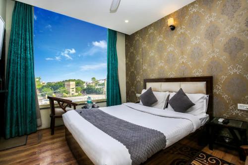 a bedroom with a bed and a large window at Hotel Wisteria Zirakpur - Main Highway Hotel in Zirakpur