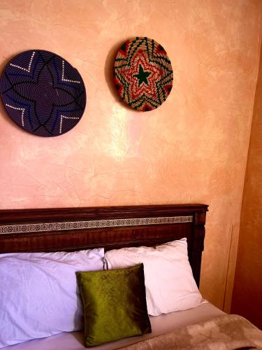 1 dormitorio con 1 cama con 2 sombreros en la pared en Double Room Private - Sea View en Tamraght Ouzdar