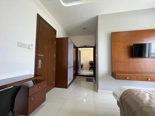 a bedroom with a bed and a tv on a wall at Ponneri Gymkhana Club in Ponneri