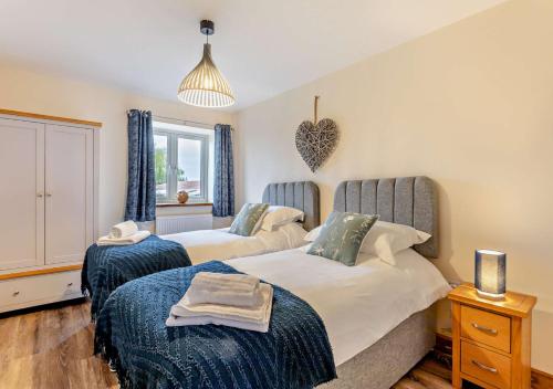 a bedroom with two beds and a window at Abbots Barn in Upwell