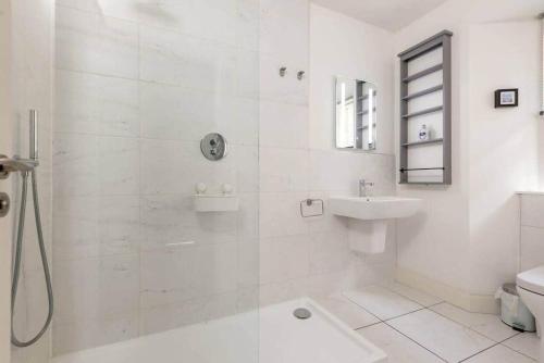 a white bathroom with a shower and a sink at Stylish Apartment - Sleeps 4 - South Street St Andrews in St. Andrews