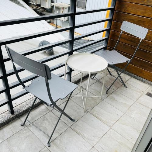 a table and a chair on a balcony at 古栗Chestnut Guest House-可包棟民宿 in Taitung City