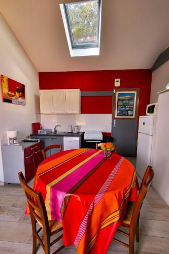 - une cuisine avec une table et une couverture colorée dans l'établissement Gîte de l'Ouvroir, à Léon