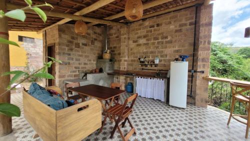 una cocina al aire libre con mesa de madera y sillas en Suíte família em Casa da Jaqueira, en Lençóis