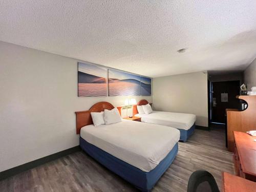 a hotel room with two beds and a desk at Antelope Inn & Suites in Clearfield