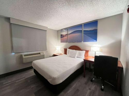 a bedroom with a bed and a desk and a chair at Antelope Inn & Suites in Clearfield