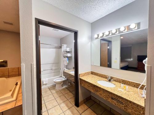 a bathroom with a sink and a toilet and a mirror at Days Inn by Wyndham Clearfield in Clearfield