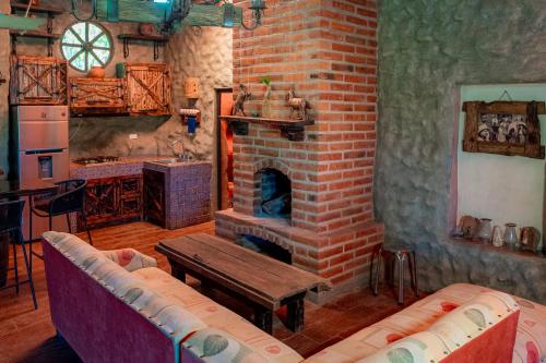 sala de estar con chimenea de ladrillo y mesa en Cabaña Romantica en Arandas