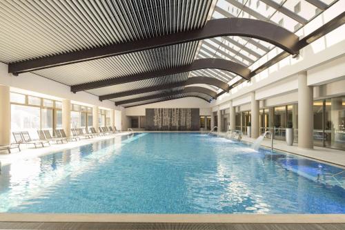 a large swimming pool in a building at Ramada Plaza by Wyndham Bucharest Convention Center in Bucharest