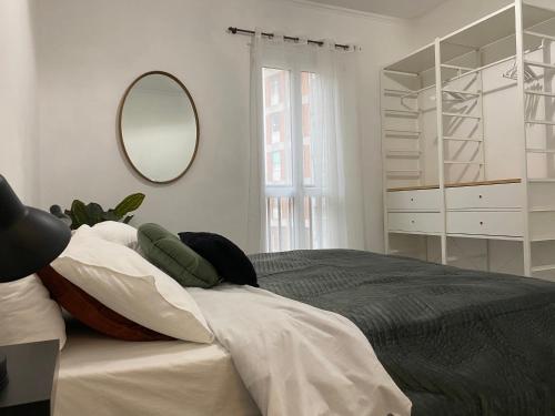 een slaapkamer met een bed met een spiegel en een dressoir bij Short Stay Pavia nuovo in città in Pavia