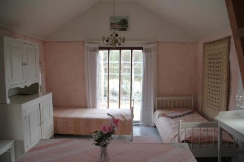 サーリヤルヴィにあるValonranta Cottageのベッド2台と窓が備わる小さな客室です。