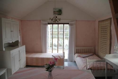 a small room with two beds and a window at Valonranta Cottage in Kalmari