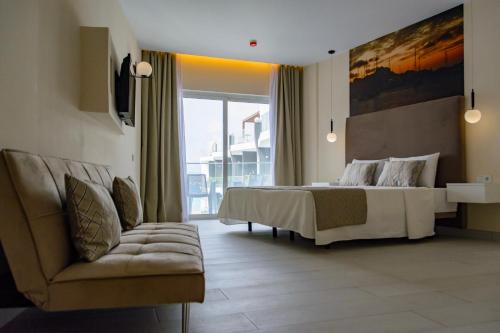 a bedroom with a large bed and a couch at Ouril Mindelo in Mindelo