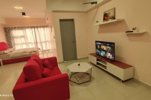 un salon avec un canapé rouge et une télévision dans l'établissement HB1511-Cyberjaya-Netflix-Wifi-Parking-Pool , 3089, à Cyberjaya