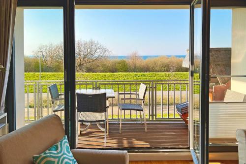 ベルガーエンデ・レートヴィッシュにあるVilla Deichgraf Ostseeblickのバルコニーにテーブルと椅子が置かれたパティオ