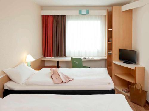 ein Hotelzimmer mit einem Bett und einem Fenster in der Unterkunft ibis Berlin City Potsdamer Platz in Berlin