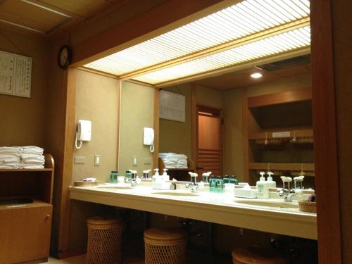 a bathroom with two sinks and a large mirror at Kawakamiya Kasuitei in Gero
