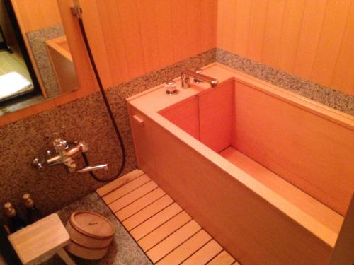 a small bathroom with a tub and a toilet at Kawakamiya Kasuitei in Gero