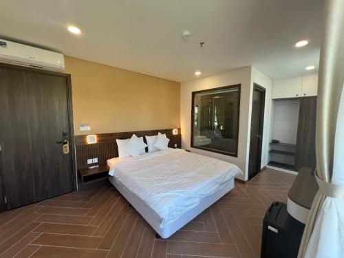 sypialnia z dużym białym łóżkiem i drzwiami w obiekcie Tanya Phu Quoc Hotel w Duong Dong