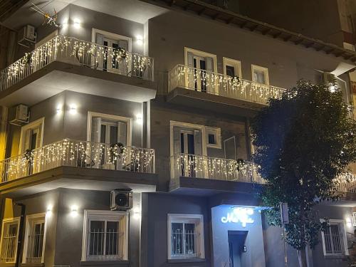un edificio con balcones y un cartel en él por la noche en MeYia studios en Tesalónica