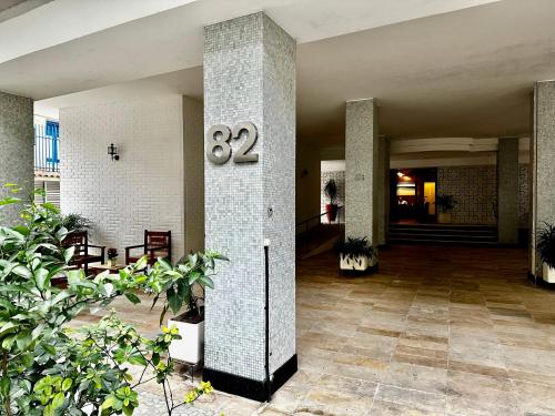 un vestíbulo de un edificio con un reloj en un pilar en Ipanema 2 quartos à 3 quadras da praia com garagem, en Río de Janeiro