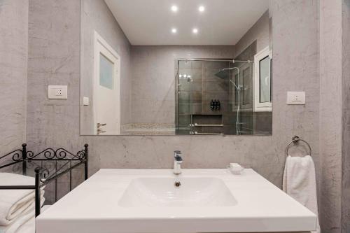 Brassbell l Cozy 1 BR apartment in Zamalek في القاهرة: حمام أبيض مع حوض ومرآة